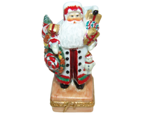Cargar imagen en el visor de la galería, A vintage ceramic Santa Claus figurine carrying a large sack of Christmas goods, set against a plain white background.